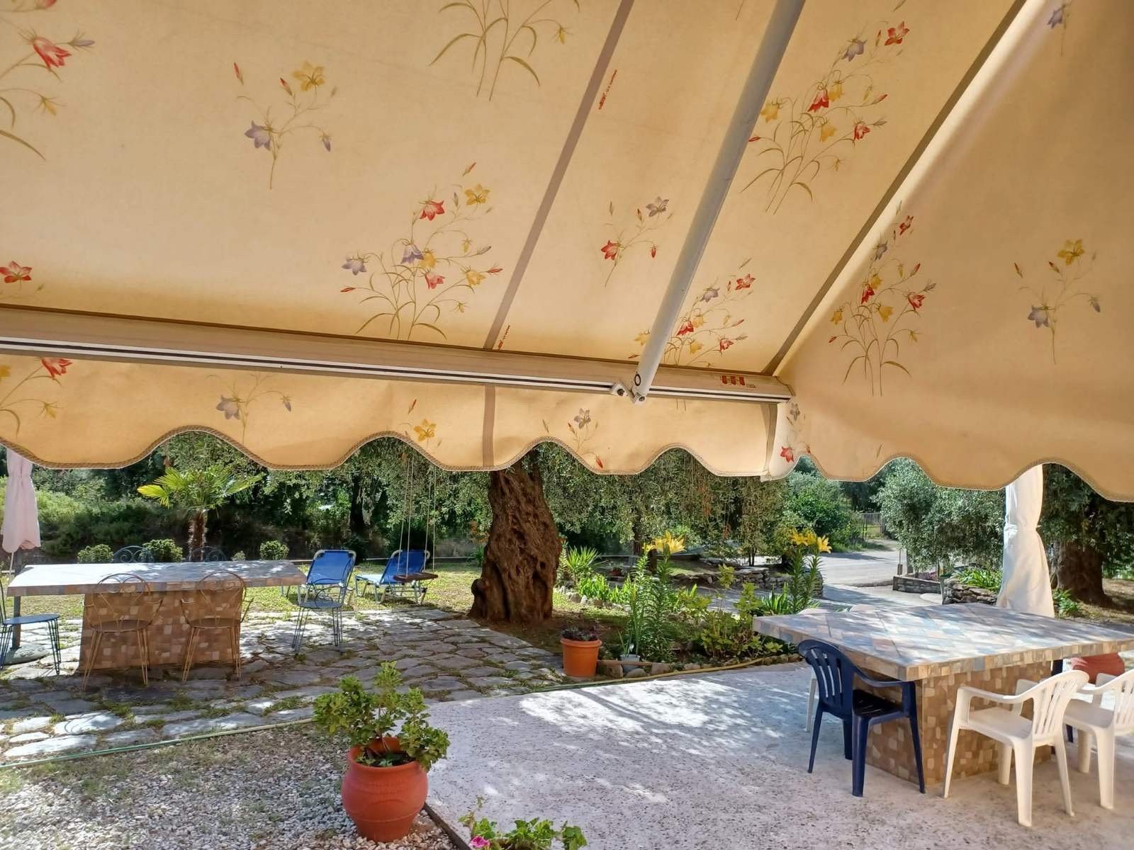 The garden dining table beneath the floral awning at Studios Betty