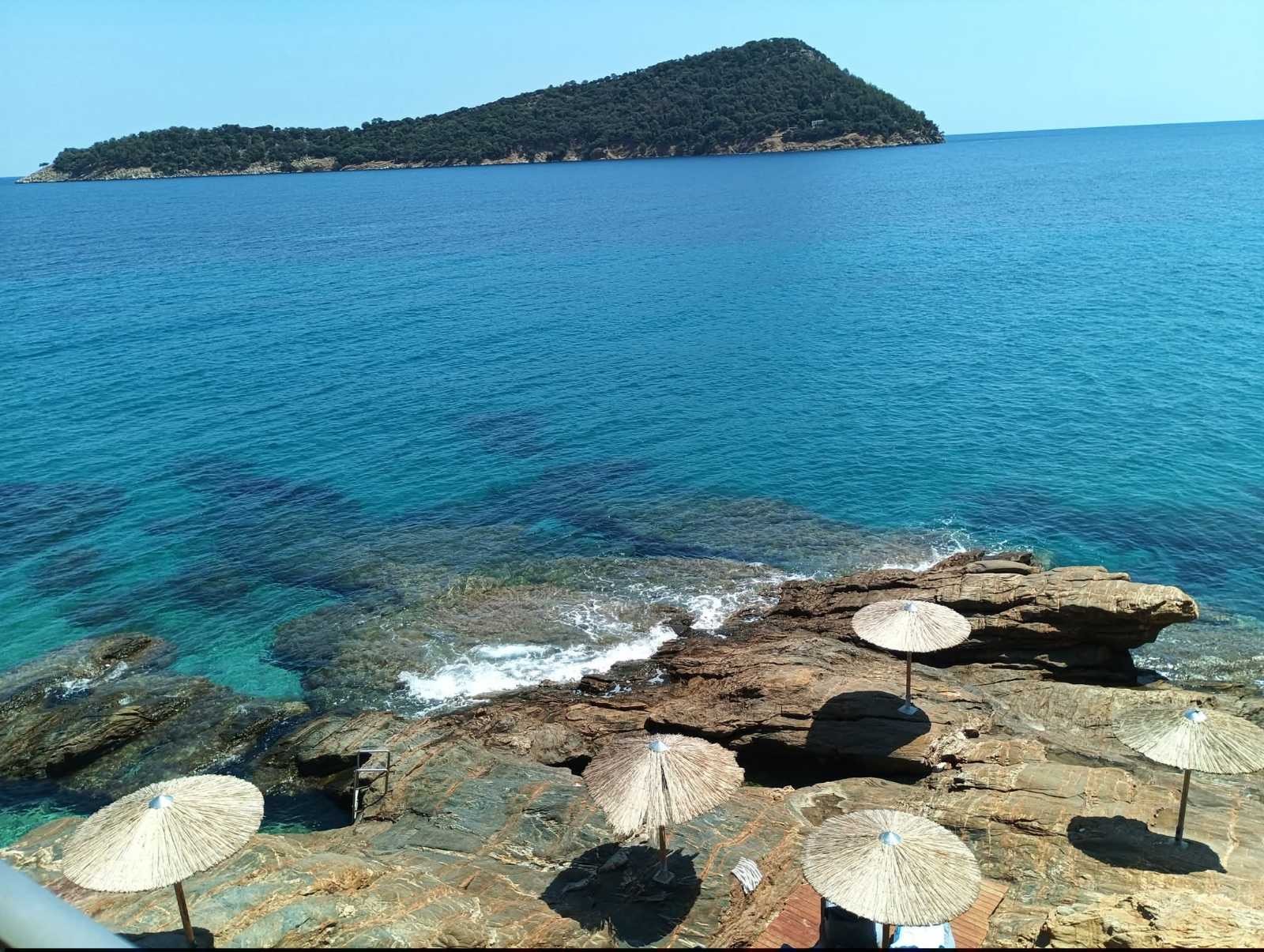 Straw umbrellas on the rocks at Paradise Beach, Thasos